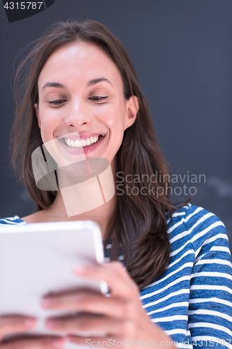 Image of woman using tablet  in front of chalk drawing board