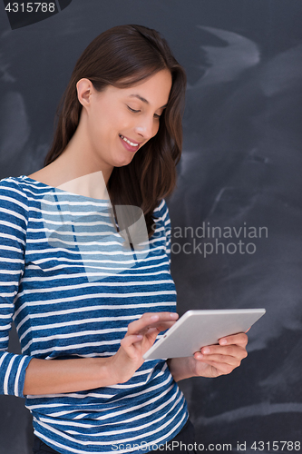 Image of woman using tablet  in front of chalk drawing board