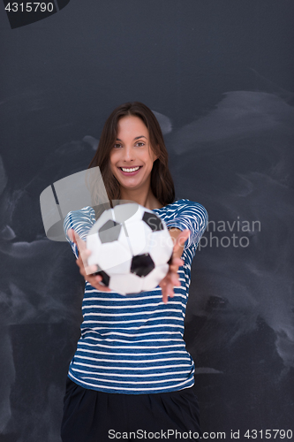 Image of woman holding a soccer ball in front of chalk drawing board