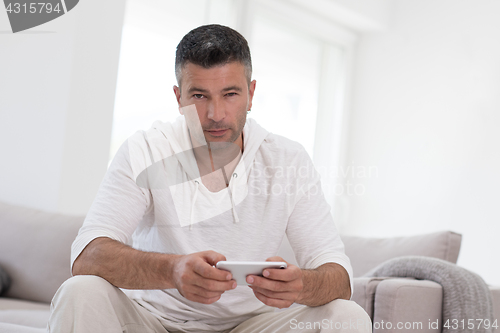 Image of young man using a mobile phone  at home