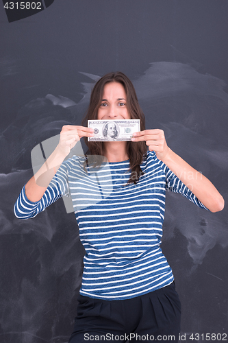Image of woman holding a banknote in front of chalk drawing board