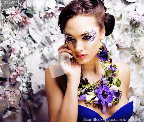 Image of floral face art with anemone in jewelry, sensual young brunette 