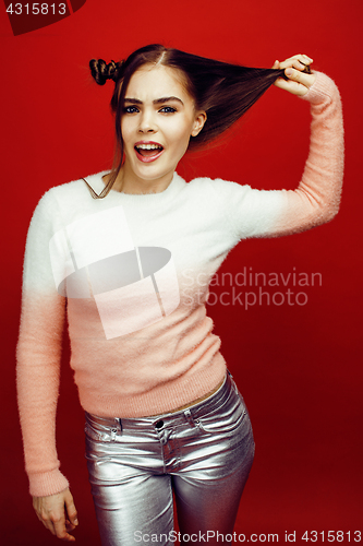 Image of young pretty emitonal posing teenage girl on bright red background, happy smiling lifestyle people concept closeup