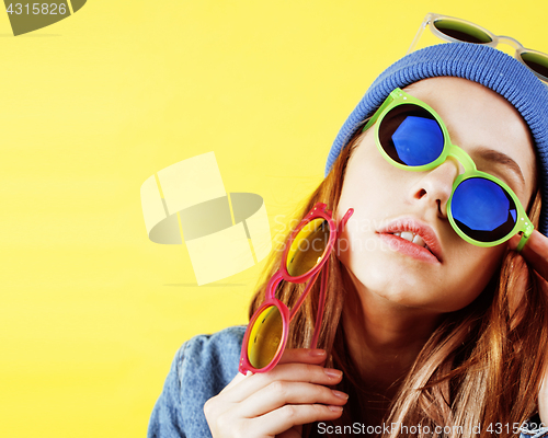 Image of young pretty teenage woman happy smiling posing on yellow background, fashion lifestyle people concept 