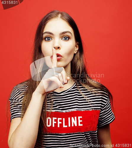 Image of young pretty emitonal posing teenage girl on bright red background, happy smiling lifestyle people concept 