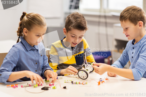 Image of happy children building robots at robotics school