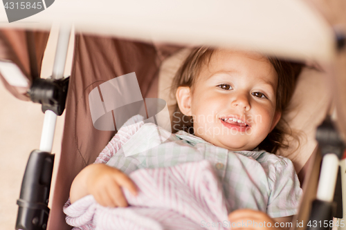 Image of little child or baby lying in stroller outdoors