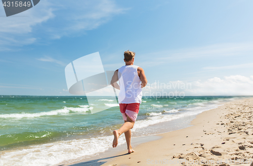 Image of happy man running along summer beach