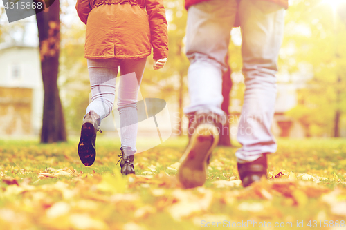 Image of young couple running in autumn park