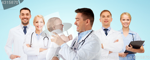 Image of happy doctor or pediatrician with baby over blue