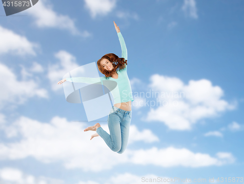 Image of smiling young woman jumping in air over blue sky