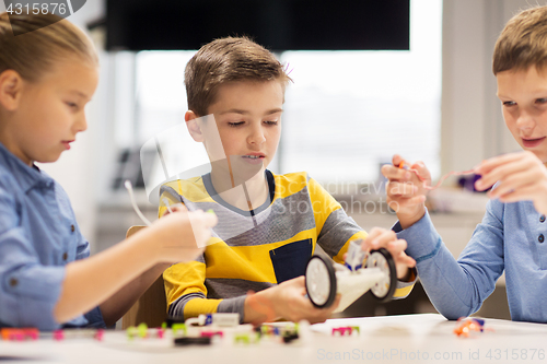 Image of happy children building robots at robotics school