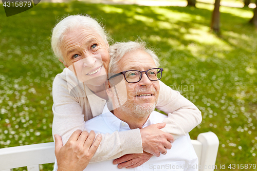 Image of happy senior couple hugging in city park