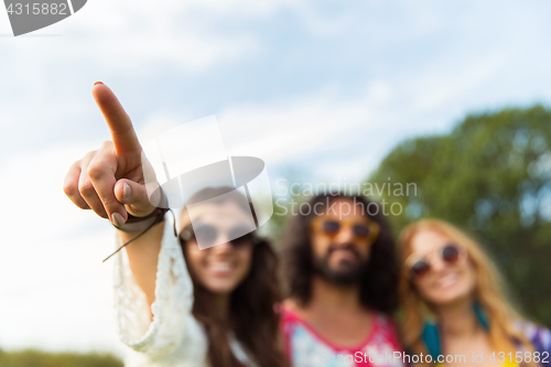 Image of happy hippie woman pointing finger outdoors