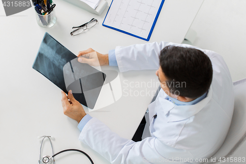 Image of doctor with spine x-ray sitting at table