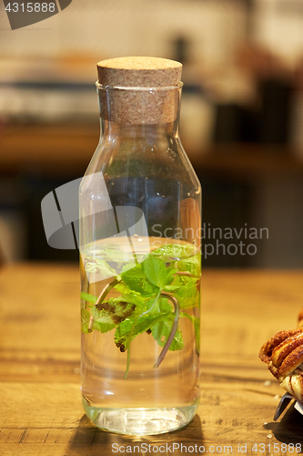 Image of fruit water with peppermint in glass bottle