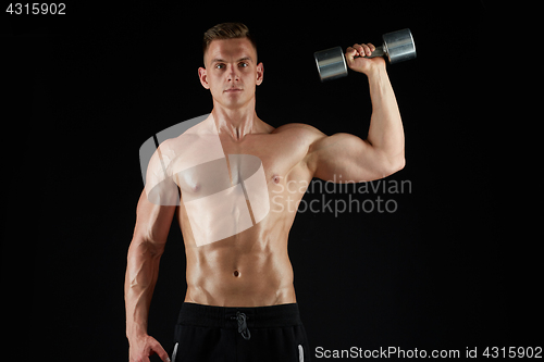 Image of man with dumbbell exercising over black background