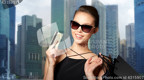 Image of happy woman with credit card and shopping bags