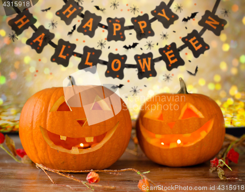 Image of carved pumpkins and happy halloween garland