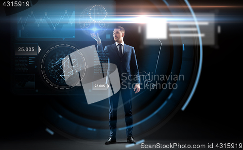 Image of businessman working with charts on virtual screen