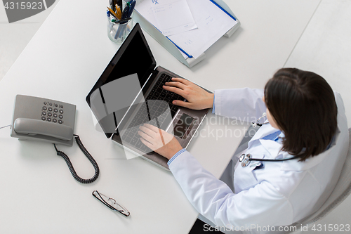 Image of woman doctor typing on laptop at clinic