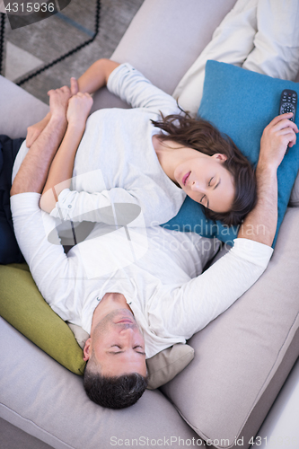 Image of Young couple on the sofa watching television top view