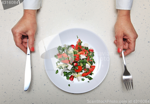 Image of hands with kitchen flatware 