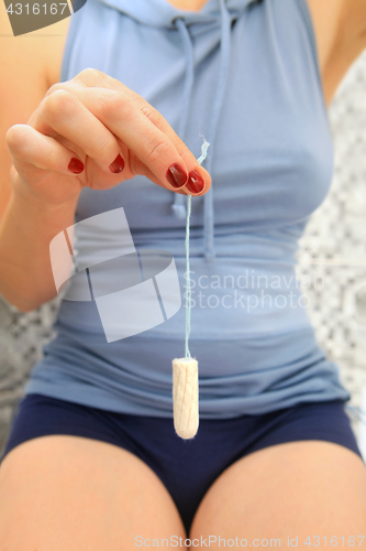 Image of white tampon in hand of woman