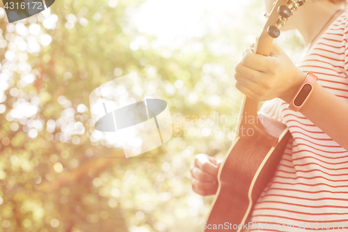 Image of Anonymous woman playing ukulele