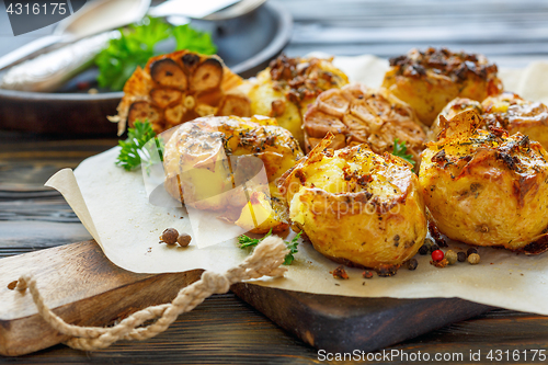 Image of Baked potatoes in skin with spices, olive oil and garlic.