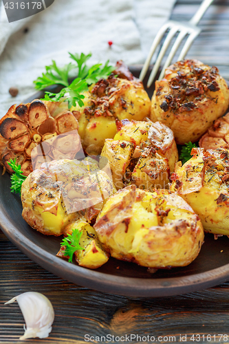 Image of Potatoes baked with garlic,thyme and green parsley.