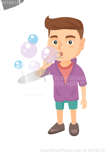 Image of Little caucasian boy blowing soap bubbles.