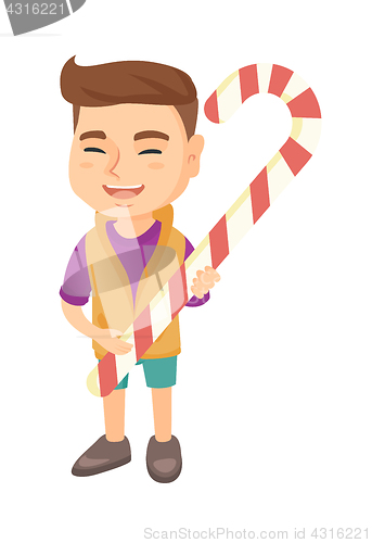 Image of Caucasian little boy holding christmas candy cane.