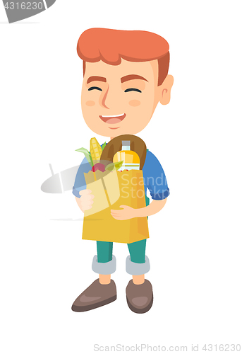 Image of Boy holding paper shopping bag full of groceries.