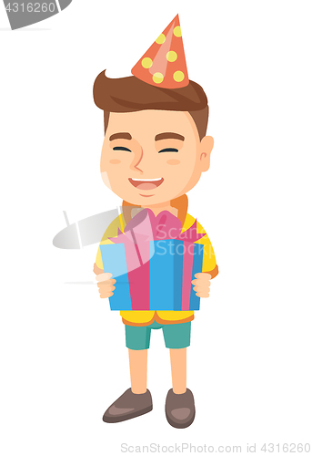 Image of Caucasian boy in birthday cap holding gift box.