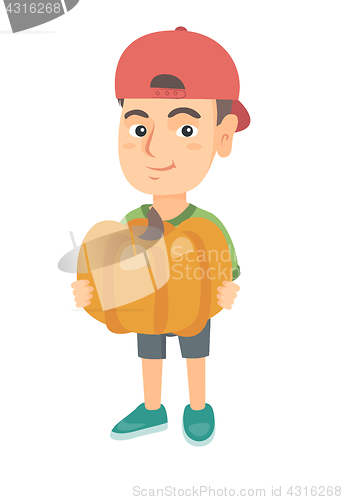 Image of Caucasian boy standing with a big orange pumpkin.