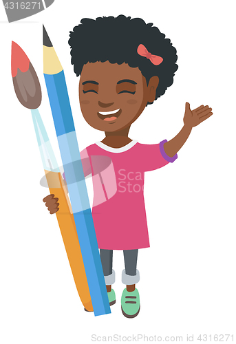 Image of Smiling girl holding big pencil and paintbrush.