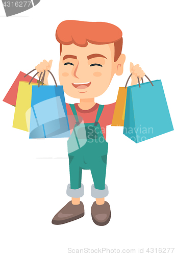 Image of Happy caucasian boy holding shopping bags.