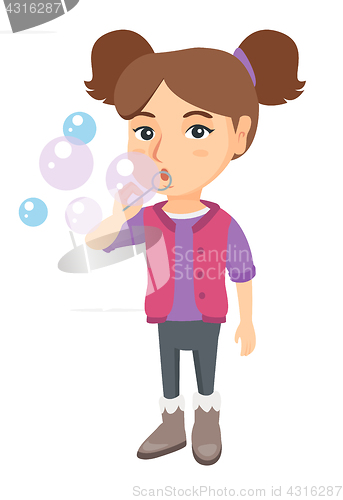 Image of Little caucasian girl blowing soap bubbles.