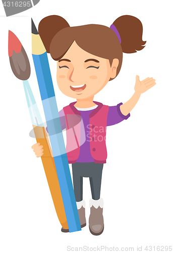 Image of Smiling girl holding big pencil and paintbrush.