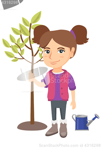 Image of Caucasian smiling girl planting a tree.