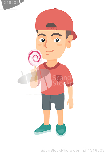 Image of Little caucasian boy holding a lollipop candy.