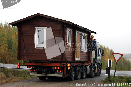 Image of Wooden Cabin Truck Transport at Yield Sign 