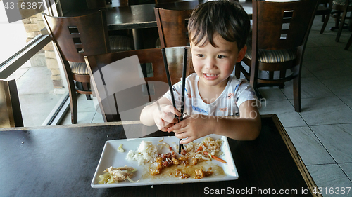 Image of Cute Young Chinese and Caucasian Boy Learning To Use Chopsticks 