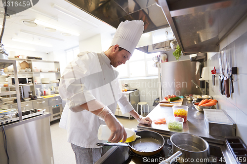 Image of happy male chef cooking food at restaurant kitchen