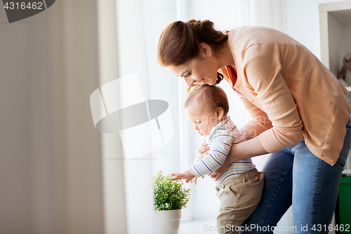 Image of happy young mother with little baby at home