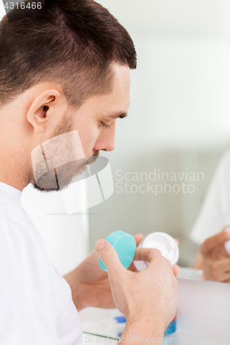 Image of close up of young man with cream at bathroom