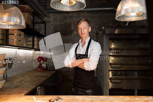Image of chef or baker in apron at bakery kitchen