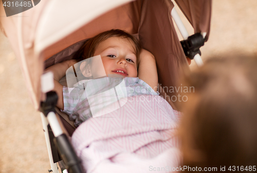 Image of little child or baby lying in stroller outdoors