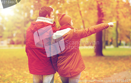 Image of happy young couple walking in autumn park